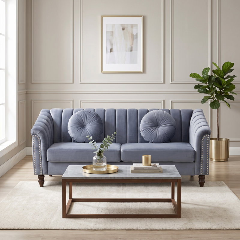 Canapé bleu clair capitonné, accoudoirs arrondis et finitions cloutées., Sofa