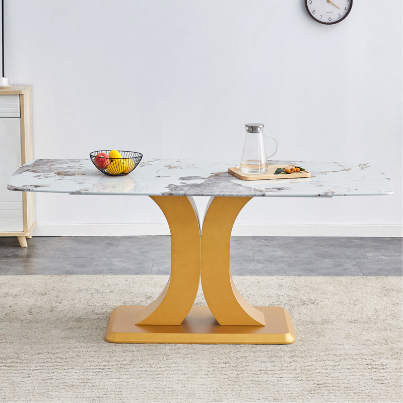 Une table de salle à manger minimaliste moderne. Plateau de table imitation verre marbré. Pieds de table en panneau de fibres à densité moyenne dorés pour la cuisine et le salon