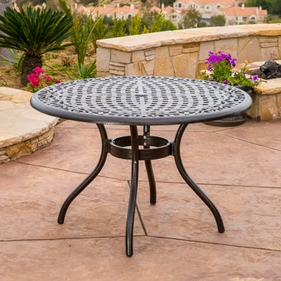 Table ronde d'extérieur de 122 cm (48 po) en aluminium moulé avec finition bronze martelé, dotée d'un plateau, d'un trou pour parasol et de pieds légèrement incurvés, idéale pour les repas sur la terrasse. Fabriqué dans un style résistant aux intempéries.