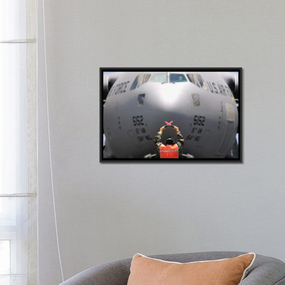 Ground Crewmember Marshals A C-17 Globemaster III To Its Parking Spot by Stocktrek Images - Photograph on Canvas