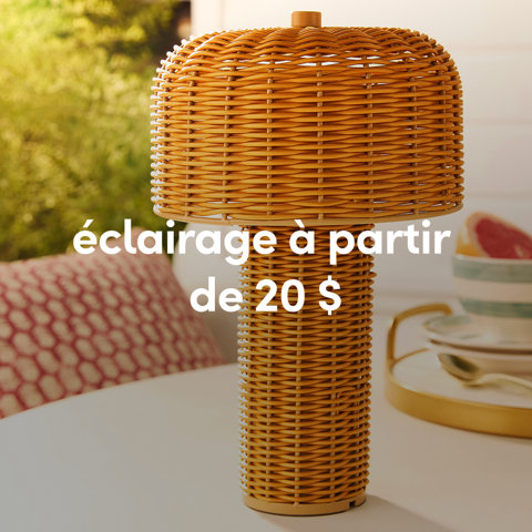 Une lampe de table extérieure en forme de champignon en osier naturel sur une table de patio blanche à partir de 20 $.