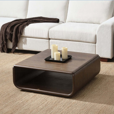 Table basse en noyer foncé avec rangement ouvert, design incurvé, placage technique robuste et structure en métal pour les espaces de vie modernes.