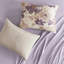 Très grand lit taupe avec édredon floral et draps à séchage rapide