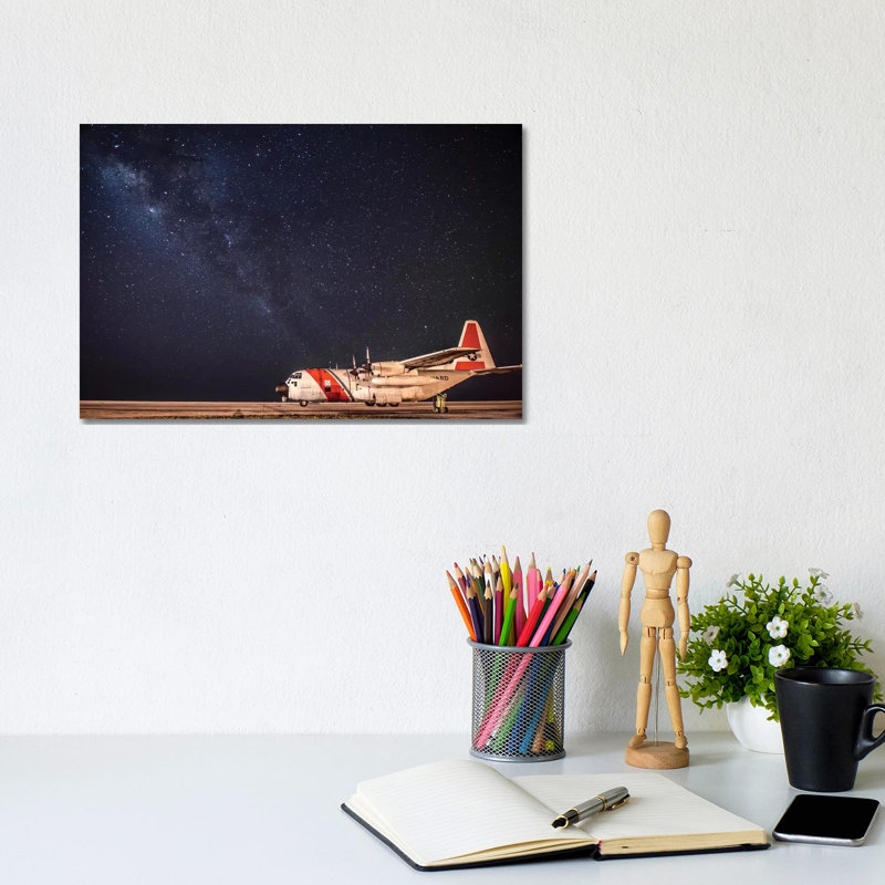 A US Coast Guard C-130 Hercules Parked On The Tarmac On A Starry Night by Stocktrek Images - Wrapped Canvas Print
