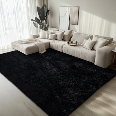 Un tapis noir doux, épais et moelleux qui convient aux salons et aux chambres à coucher.