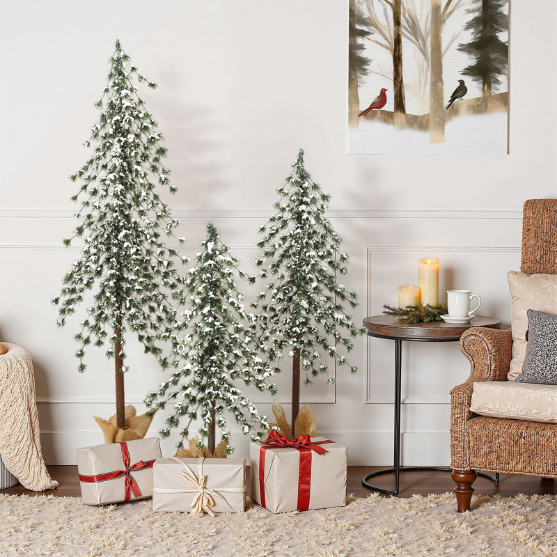 Ensemble d'arbres de Noël artificiels saupoudrés de neige avec bases recouvertes de toile de jute