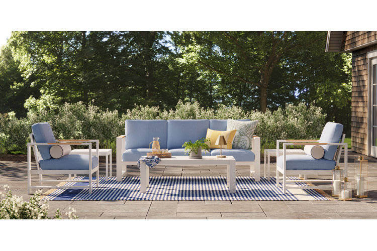 A light blue patio conversation set with a sofa, two accent chairs, and a white rectangle coffee table