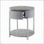 Table de bout grise et brillante en chrome avec tiroir, combinant style moderne et amplement de rangement pour des salons élégants.