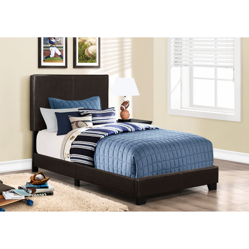 Lit simple brun pour un cadre de couchage confortable dans une chambre à revêtement foncé
