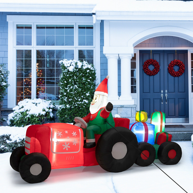 Père Noël conduisant un tracteur gonflable