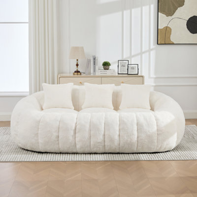 Canapé deux places incurvé en forme de pétale de 190 cm de large, sans ossature apparente, en fausse fourrure ultra douce beige, assise profonde en mousse comprimée, sans assemblage, idéal pour le salon, la chambre ou un appartement.