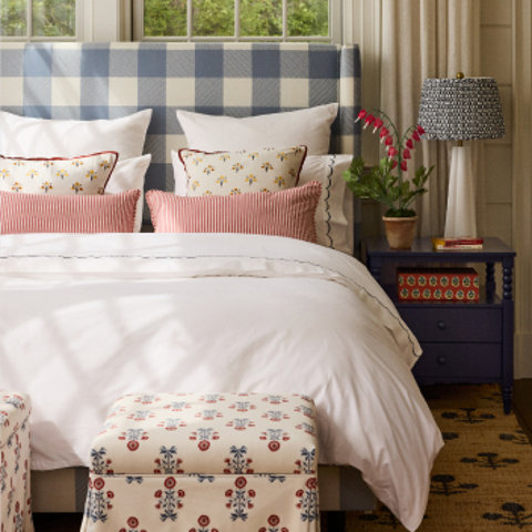 Bedroom with white bedding and blue plaid headboard.