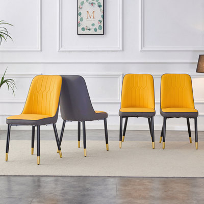 Une chaise de salle à manger moderne avec un dossier en polyuréthane bicolore jaune-orange foncé et des pieds en métal noir