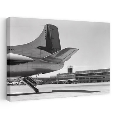 1950s TAIL OF COMMERCIAL AIRPLANE WITH OTHER PLANES AND AIRPORT TERMINAL AND TOWER IN BACKGROUND PHILADELPHIA PA USA by H. Armstrong Roberts - Wrapped Canvas Print