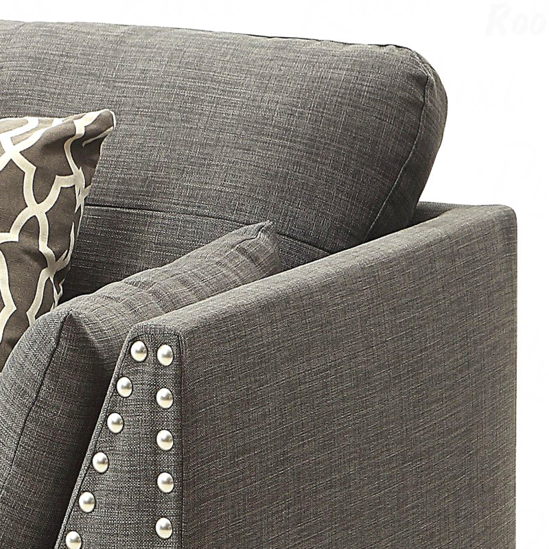 Chaise avec accoudoirs évasés gris clair et coussins décoratifs parfaits pour les salons modernes