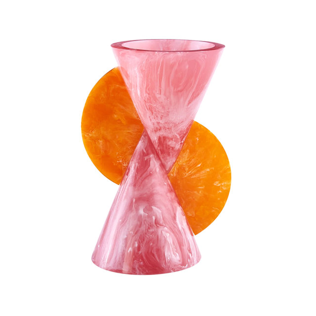 Modern sculptural vase featuring a pink and white marbled resin hourglass shape accented with two circular orange resin decorative elements.