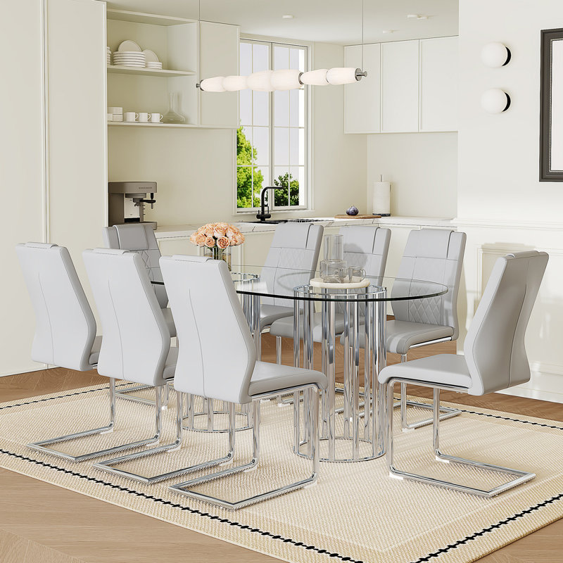 Ensemble de salle à manger 9 pièces, table ovale en verre trempé transparent de 180 cm, chaises à dossier haut en similicuir à motif quadrillé, piètement en métal argenté arqué, gris pâle