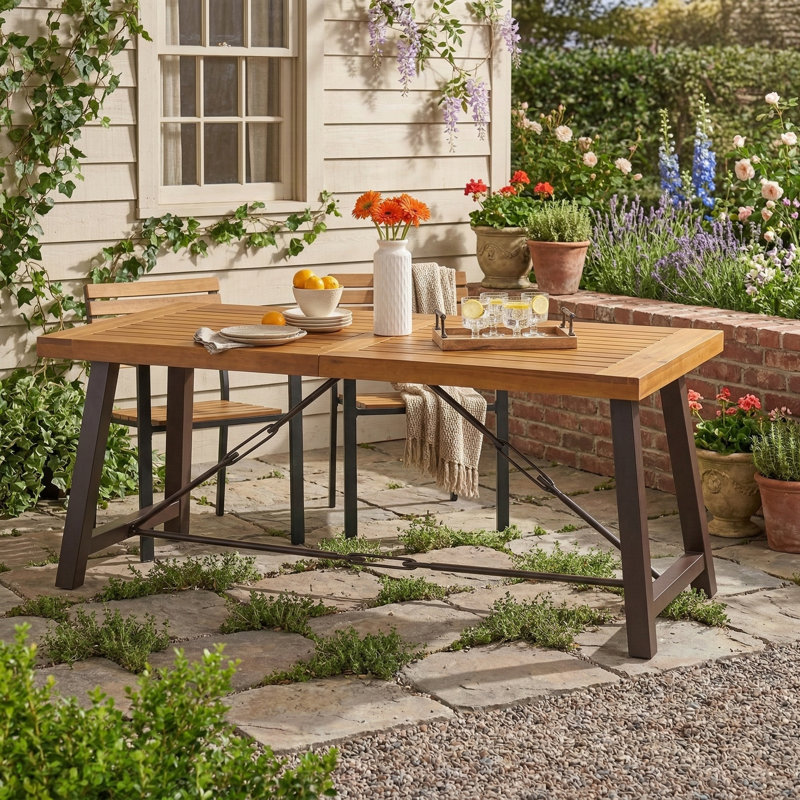 Table de salle à manger d'extérieur avec plateau en bois d'acacia et base en métal. Finition en teck.