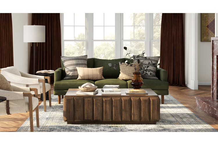 Living room with fall decor, green velvet sofa, wood coffee table, and neutral accent chairs