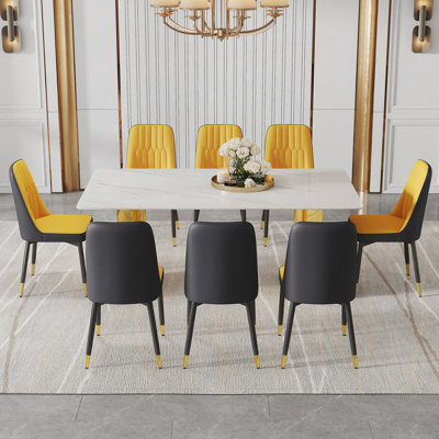 Ensemble de table et de chaises. La table a un plateau en verre avec des autocollants en imitation marbre et des pieds dorés en acier inoxydable ornés de 8 chaises de salle à manger en polyuréthane.