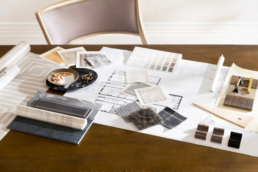 Interior design samples and architectural plans laid out on a table.
