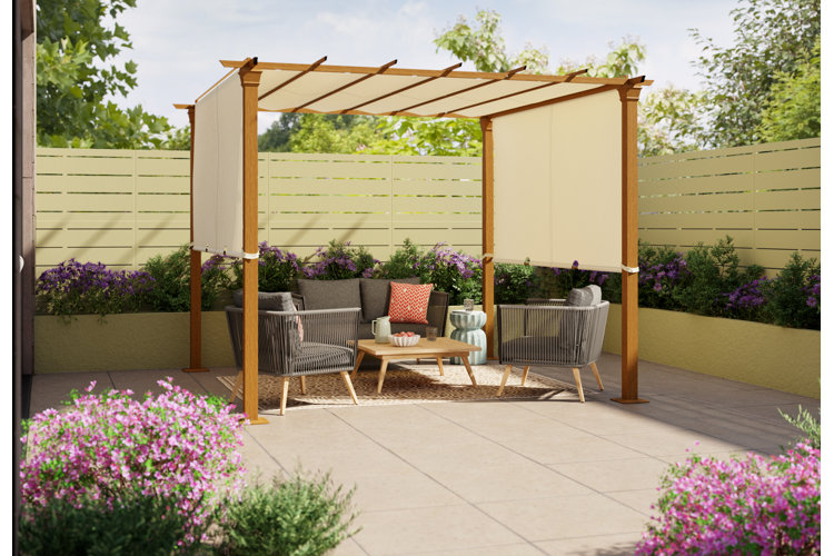 Patio seating area beneath a covered pergola and surrounded by a flower border and wood fencing.