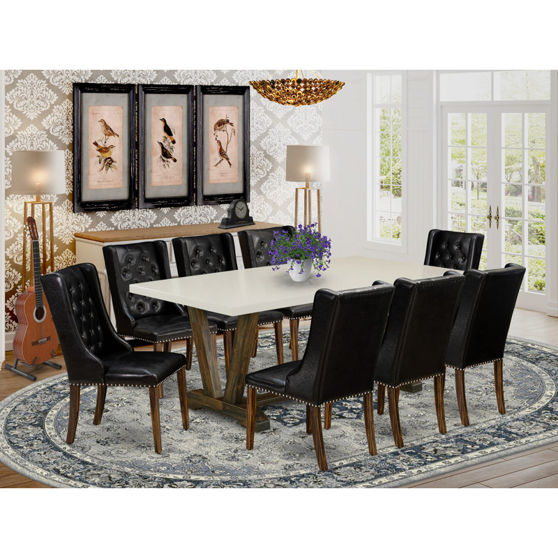 Cet ensemble de table de salle à manger 9 pièces comprend une table rectangulaire en bois avec pieds en V et 8 chaises rembourrées en similicuir noir, en lin brossé blanc.