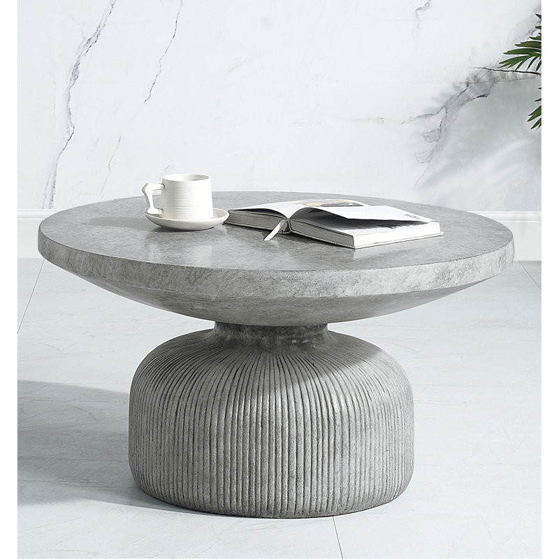 Table basse élégante en ciment gris patiné, forme ronde, table à piédestal tendance avec plateau