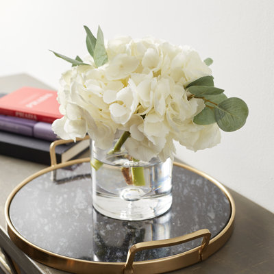 Ensemble d’hortensias blancs dans un vase cylindrique en verre