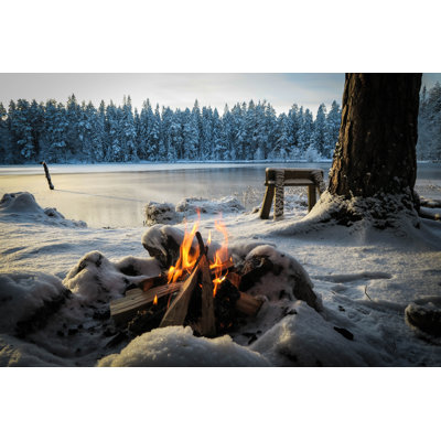 En LÃ¤gereld I FÃ¶rgrunden En Solig Vinterdag Vid En Frusen SkogssjÃ¶ I Ett SnÃ¶igt Vinterlandskap Utan MÃ¤nniskor by Sanna Hermansson - Wrapped Canvas Print