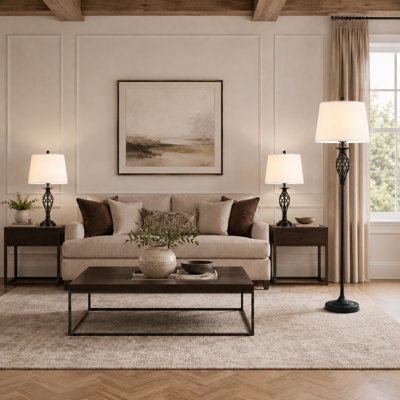 Un ensemble d'éclairage en trois pièces noir et blanc comprenant une lampe de table et une lampe sur pied; Doté de tiges en métal avec des bases rondes et des abat-jours en tissu, il peut être placé dans le salon.