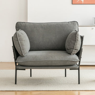 Fauteuil épais avec tissu doux, structure en métal robuste, coussins et poches latérales