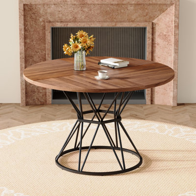 Une table de salle à manger circulaire d'un diamètre de 47,3 pouces, comprenant 4 plateaux de table en bois aggloméré à grain de bois de noyer, des supports en métal en forme de sablier et une table de salle à manger de style industriel moderne pour 4 à 6 personnes.