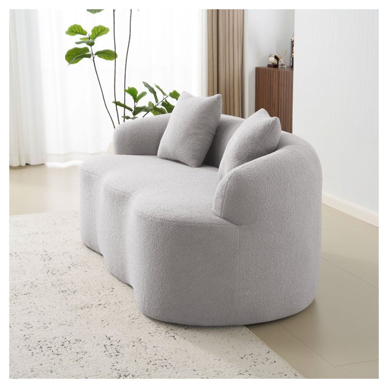 Causeuse courbée grise avec accoudoirs ronds, revêtement minimaliste en polyester pour le salon