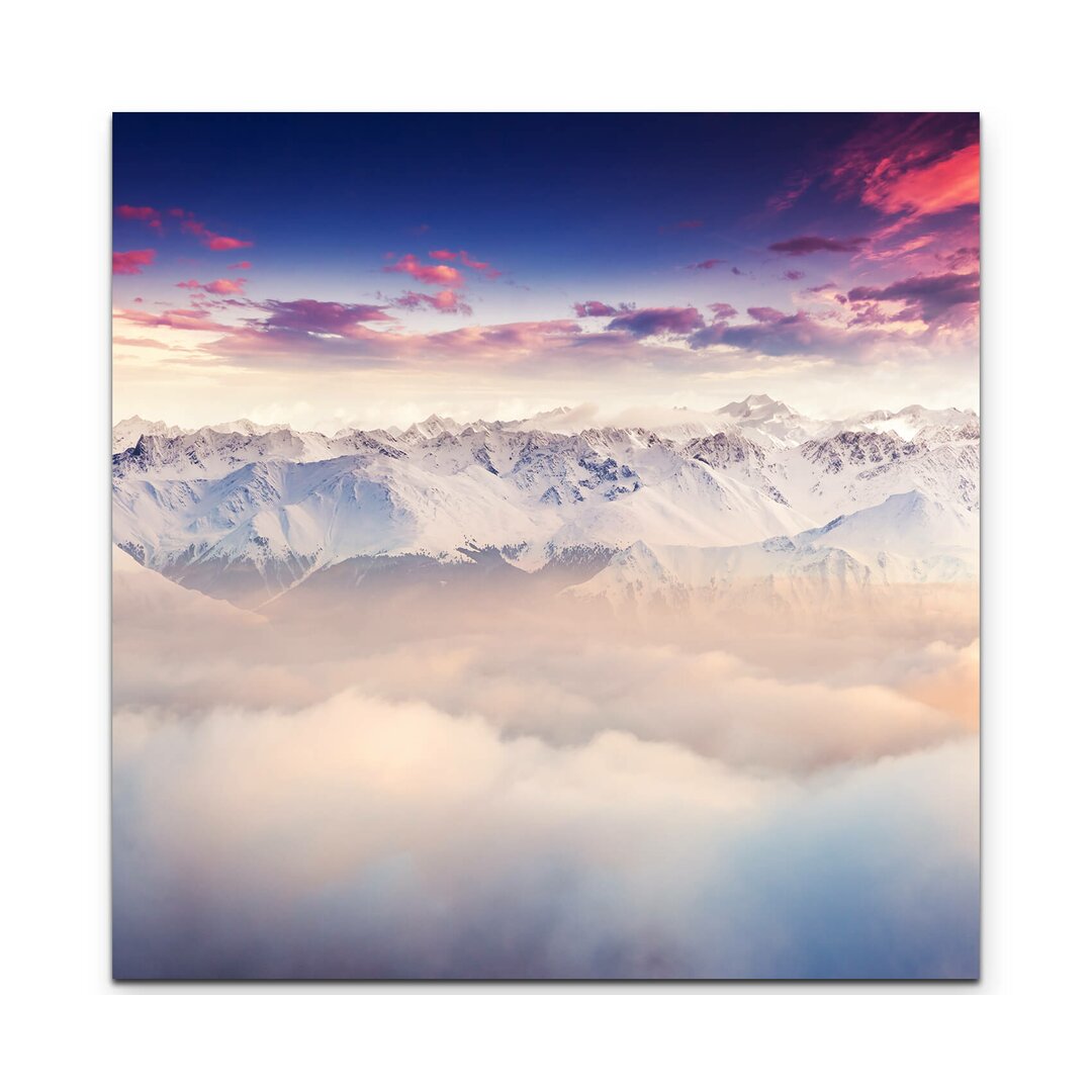 Leinwandbild Schneebedeckte Berggipfel über den Wolken