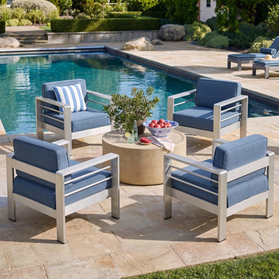 Ensemble de conversation d'extérieur moderne Caggiano pour 4 personnes en MGO et aluminium, avec fauteuils club rembourrés et table basse ronde en forme de tambour.