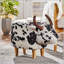 Charmant repose-pieds en forme de vache, tabouret d'appoint moderne avec des cornes de velours et des pieds en bouleau pour une décoration polyvalente