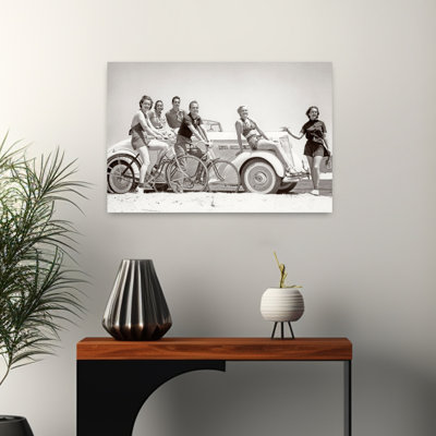 1930S Group Of Men And Women Wearing Bathing Suits Casual Clothes On Bicycles In A Car On Beach All Looking At Camera Smiling Classic Retro Vintage...