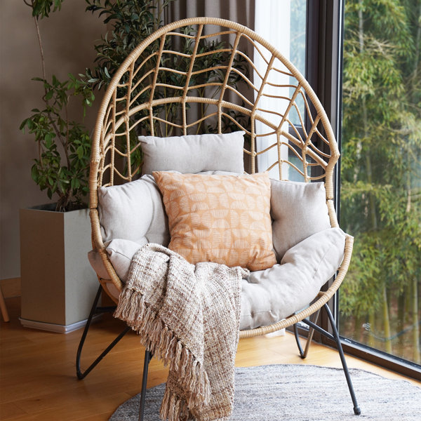 Wicker chair with cushions and a plaid close-up on background of