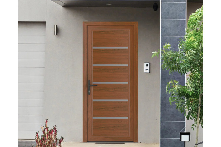 modern wood front door with horizontal metal inlays, black hardware, gray exterior walls, and minimalist landscaping beside the entryway