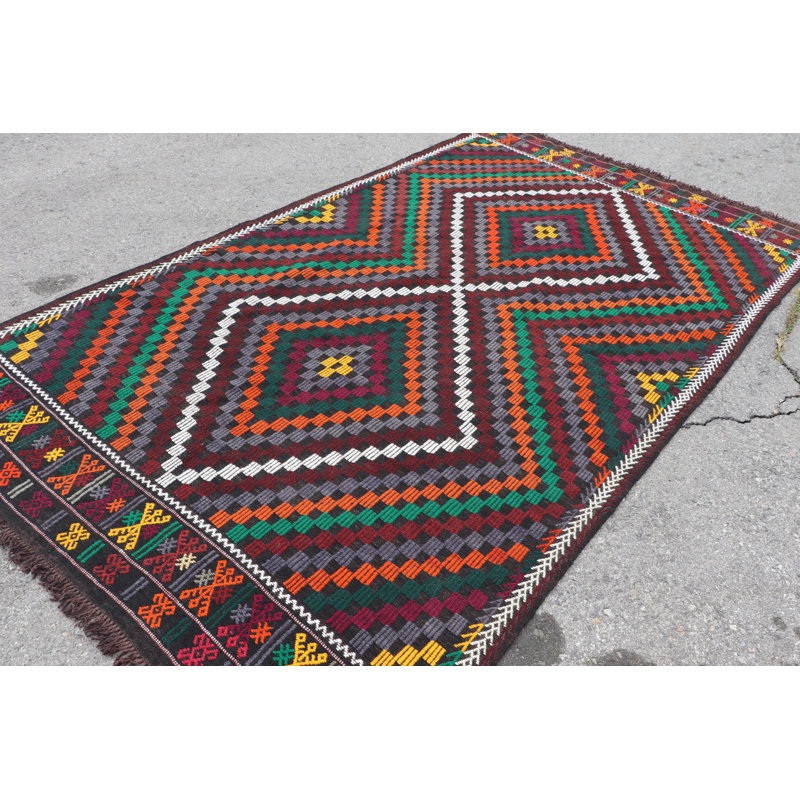 Tapis turc vibrant fabriqué à la main dans des motifs géométriques rouge, vert et orange pour un décor traditionnel