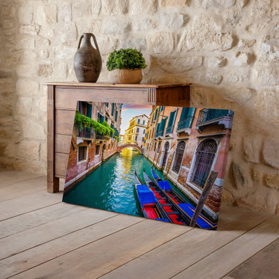 Toile, "Tranquil Venetian Canal Scene At Sunset", avec deux gondoles traditionnelles avec voiles bleues et rouges vibrantes