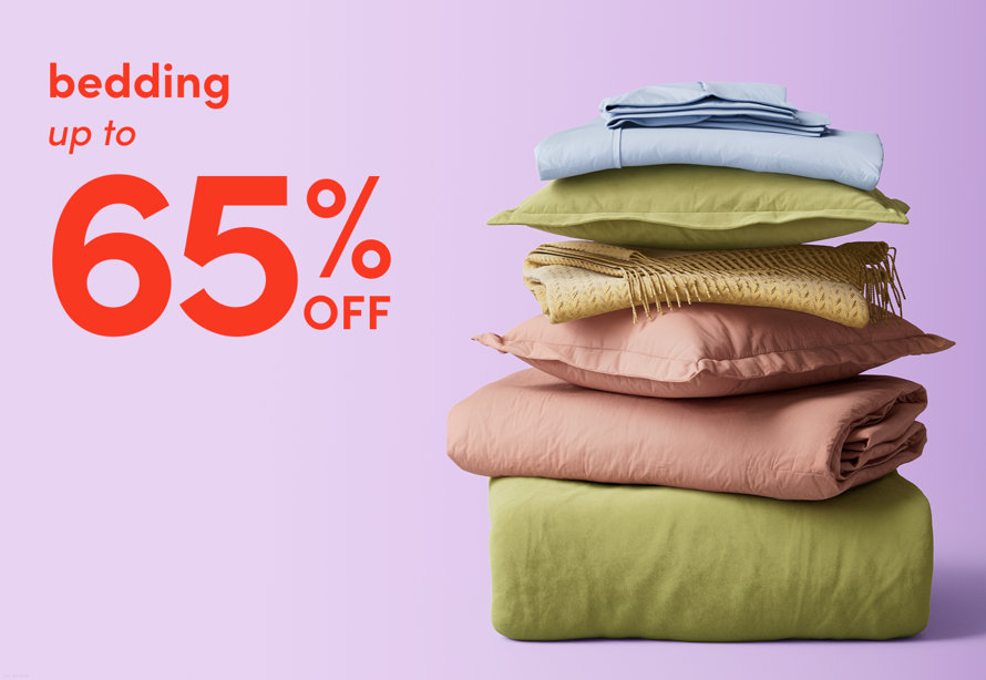 Bedding up to 65% off with a stack of pillows, blankets, and duvets in soft pastel colors.
