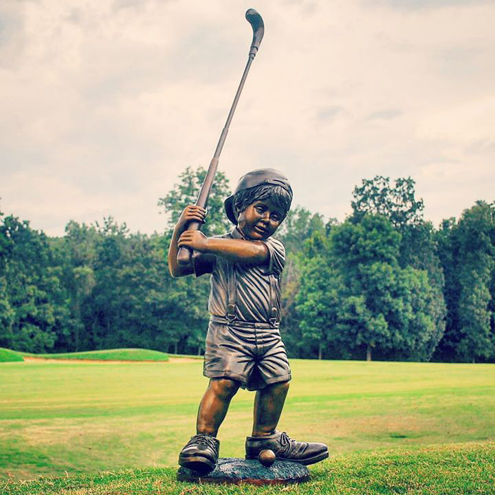 Sculpture bronze d'un garçon jouant au golf dans de grandes chaussures