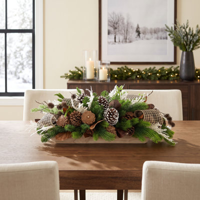 Centre de table festif avec sapins, pommes de pin et nœuds