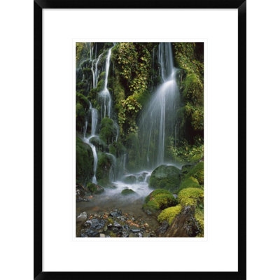 " Waterfall Cascading Over Mossy Rocks "
