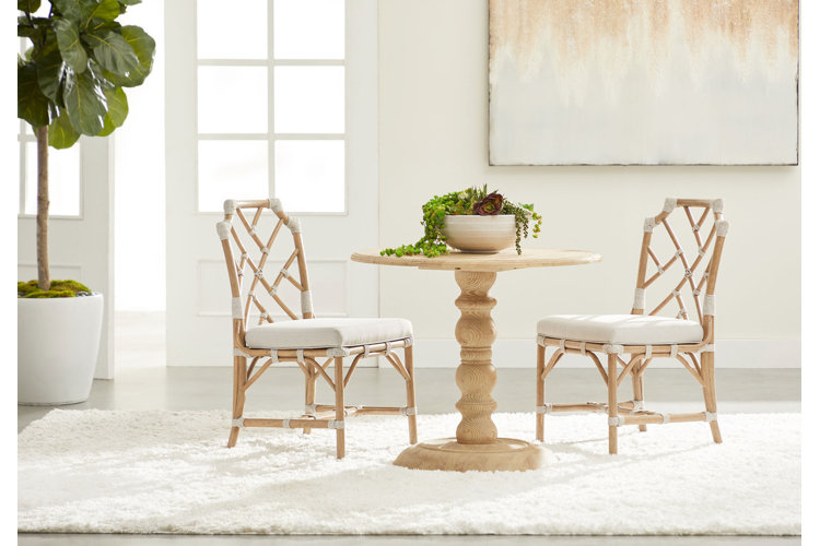 small round dining table with two rattan chairs