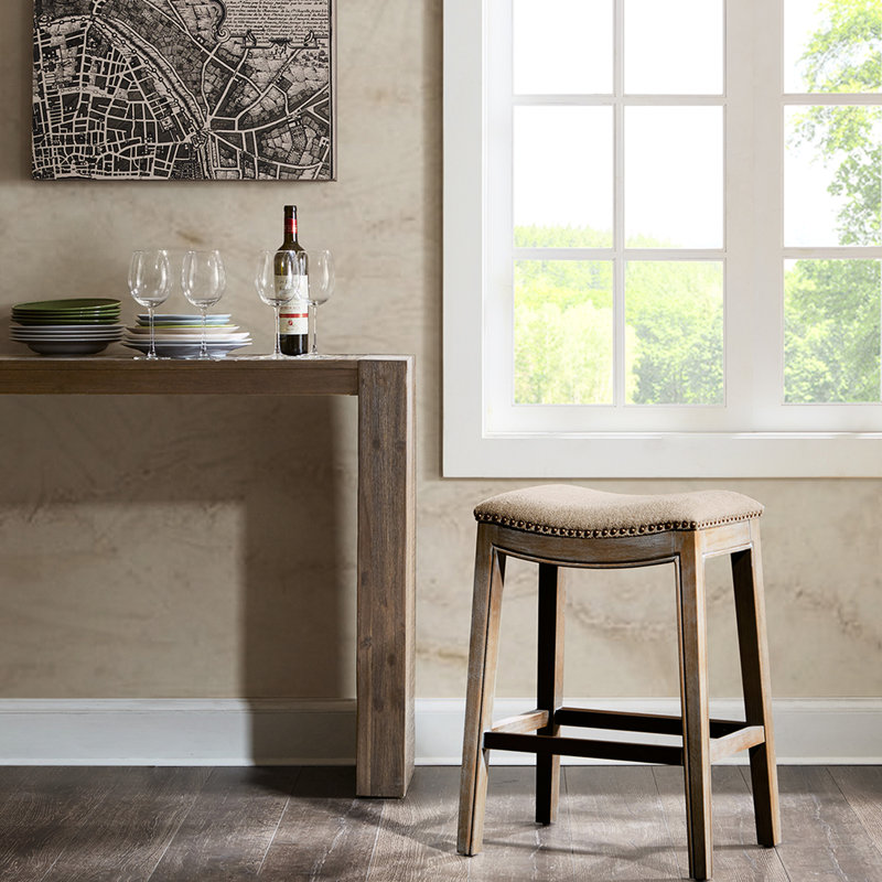 Tabouret de bar à selle élégant avec plinthe en métal et repose-pieds intégré.