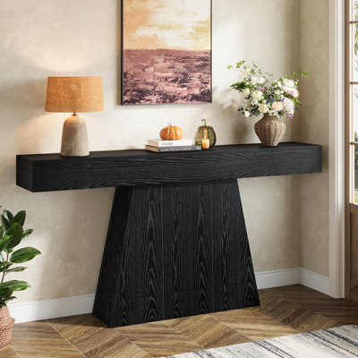 Console 63 po, table d'entrée noire avec base trapézoïdale, canapé long et étroit