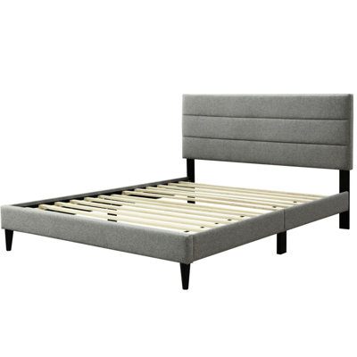 Grand lit gris dans une boîte avec tête de lit en tissu